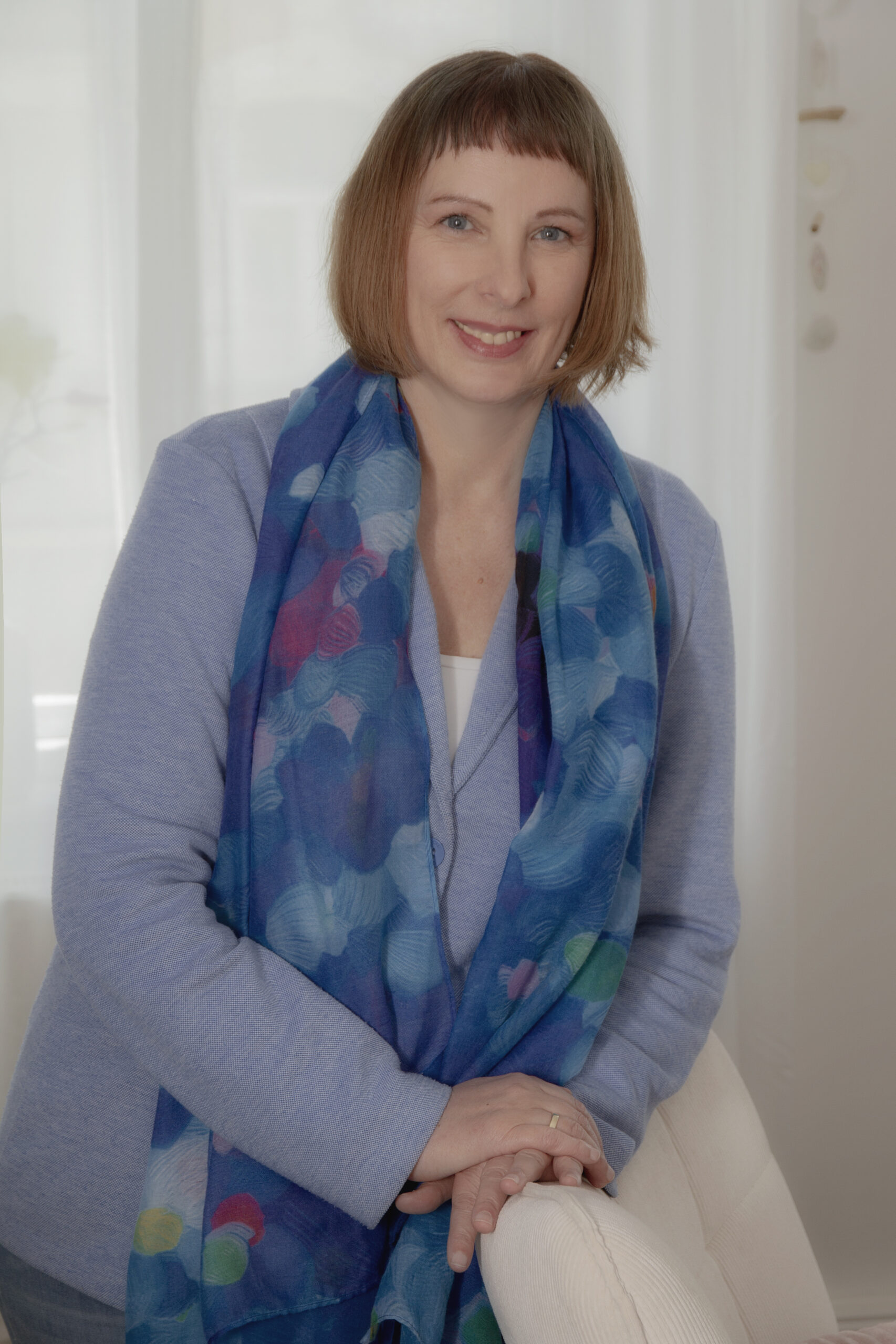 Psychotherapeutin Edeltraud Kalcher Wien steht an einen Sessel gelehnt in der neuen Praxis